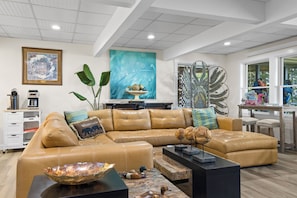 A modern living room with a leather sectional sofa, a coffee table, and a decorative peacock sculpture.