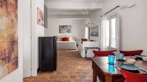 A room with a bed, a dining table with chairs, a refrigerator, and artwork on the walls. - Le Dimore del Corso Acireale II Sicily Stay near Catania Taormina, the Sea, Etna (Acireale)