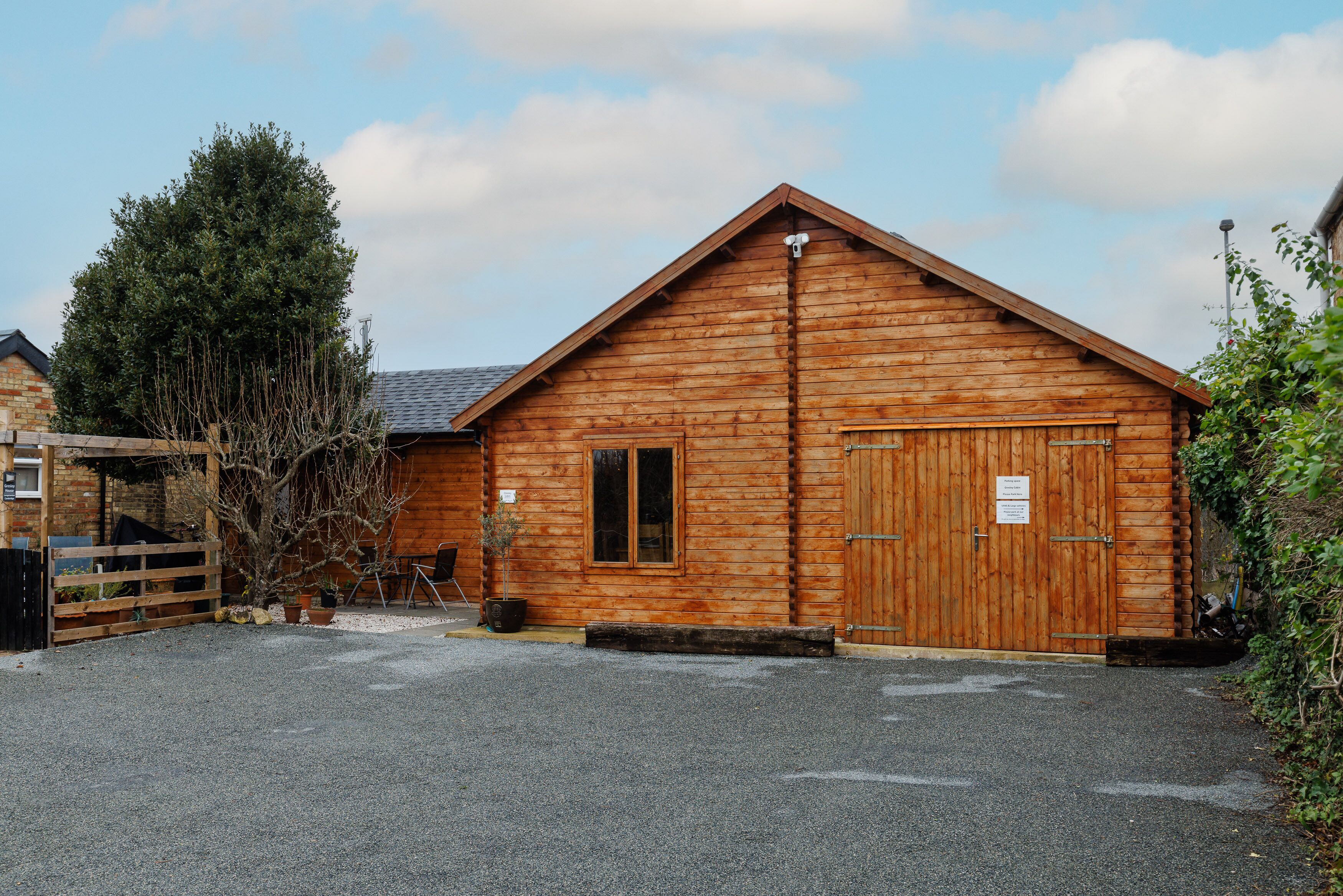 A wooden building with a sloped roof, a large door, and a small window.