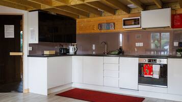 Een moderne keuken met witte kasten, een roestvrijstalen spoelbak en een rood tapijt.