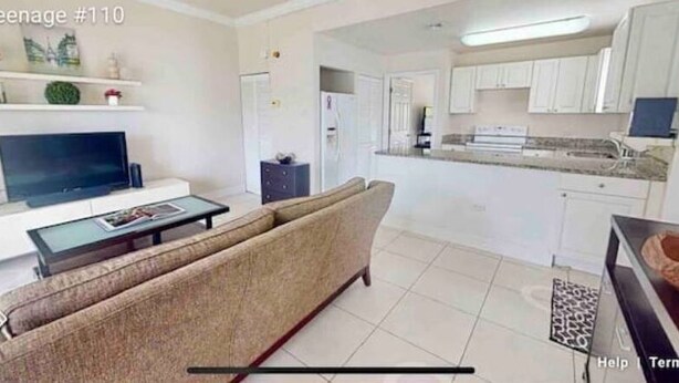A modern living room with a sofa, TV, and coffee table. - Waterfront Sanctuary Cove, 2Bed 2Bath, King Bed, Pool, Porch at Grand Harbour. (Grand Harbour)