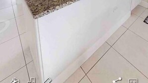 A kitchen with white cabinets, a granite countertop, and a window. - Waterfront Sanctuary Cove, 2Bed 2Bath, King Bed, Pool, Porch at Grand Harbour. (Grand Harbour)