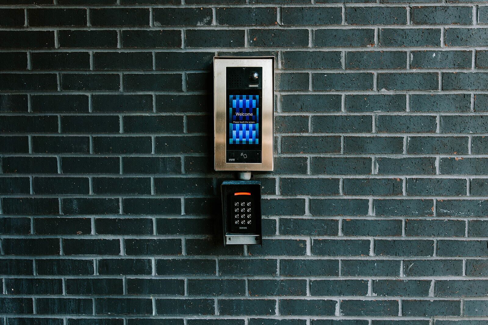 Ett väggmonterat intercomsystem med knappsats och digital display.