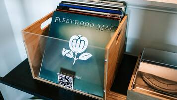 Una caixa de fusta amb l'etiqueta 'Fleetwood Mac' i un codi QR, que conté CDs o discos.