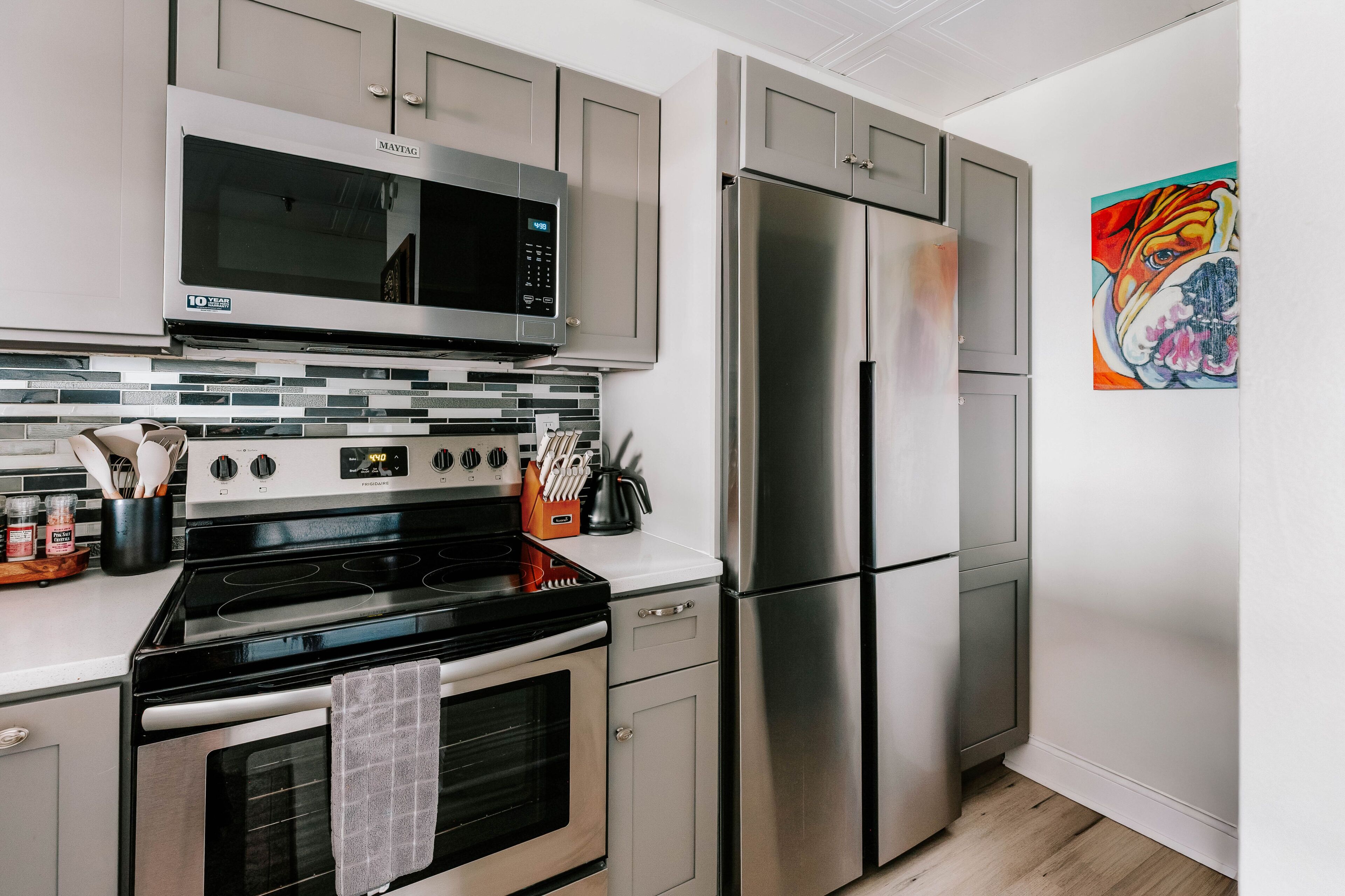 A modern kitchen with stainless steel appliances, a microwave, oven, and refrigerator.