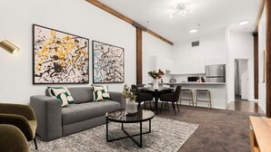 A modern living room with a grey sofa, a coffee table, and artwork on the wall. - Heart of Darling Harbour (Pyrmont)