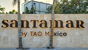 Ein Schild mit dem Text 'santanar by tao mexico' an einer Steinwand.