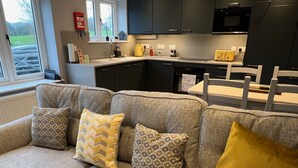 Une cuisine moderne avec des meubles de couleur sombre, un four à micro-ondes et un grille-pain.