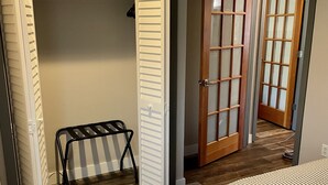 Une chambre à coucher comprenant un lit, une armoire et une porte donnant sur une autre pièce.