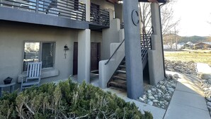Une maison moderne à deux étages, dotée d’un balcon, d’un escalier et d’un chemin en pierre.
