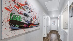 Ein Korridor mit großformatiger Graffiti-Kunst an der Wand, Holzboden und weißen Wänden.
