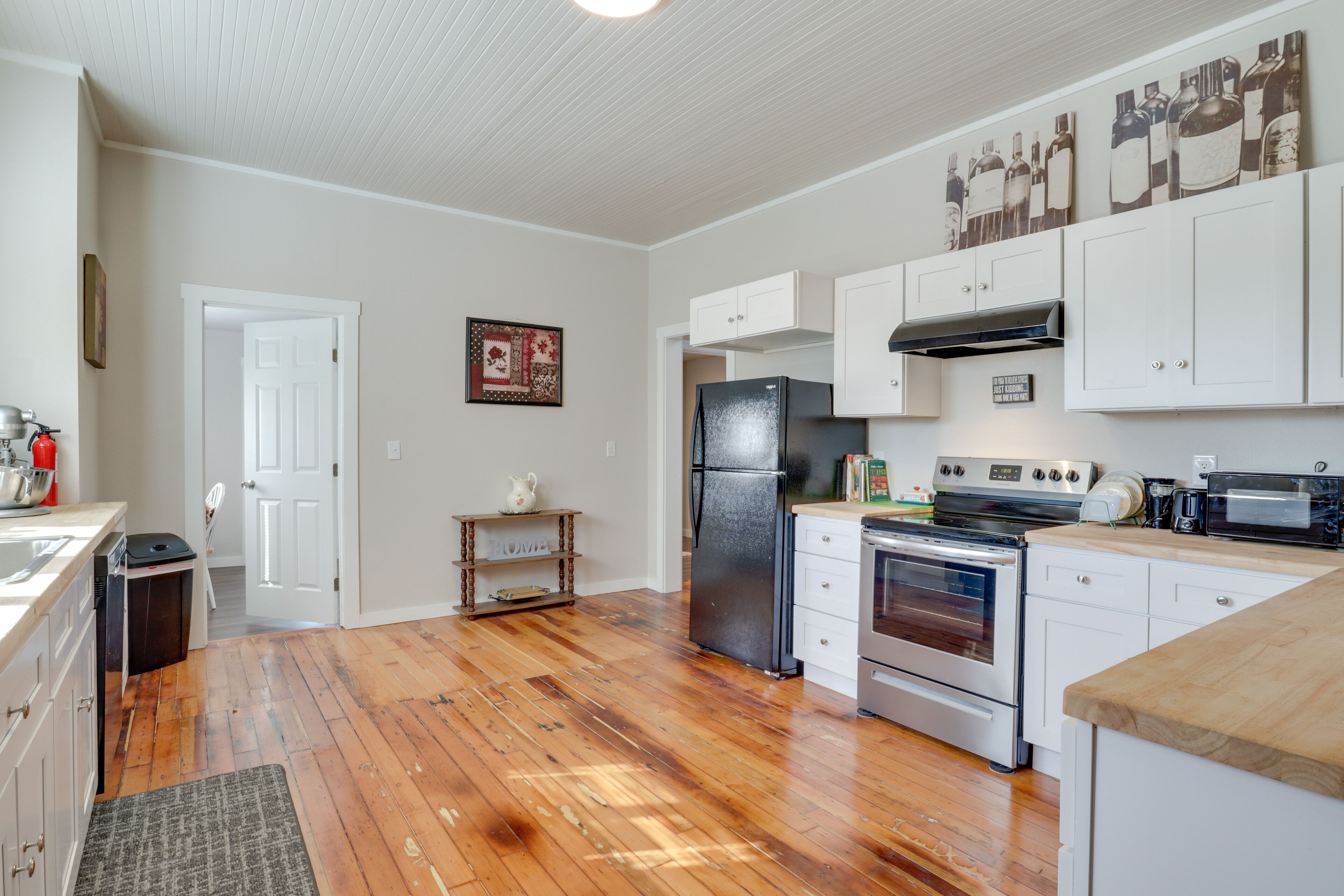 A kitchen with white cabinets, a black refrigerator, an oven, and a microwave.