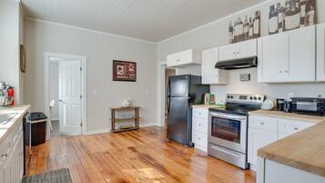 A kitchen with white cabinets, a black refrigerator, an oven, and a microwave.