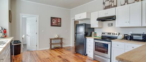 A kitchen with white cabinets, a black refrigerator, an oven, and a microwave.