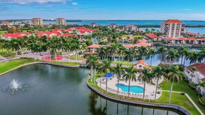 A resort with a central pool, surrounded by palm trees and red-roofed buildings. - Sunny St Pete Getaway With Shared Pool & Hot Tub (St. Petersburg)