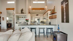 A modern kitchen with a central island, bar stools, and decorative items.