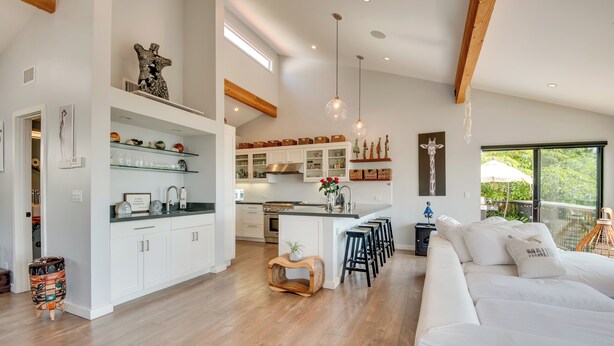 A modern kitchen with white cabinets, a central island, and pendant lighting.