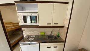 A compact kitchenette with a microwave, sink, and small refrigerator.