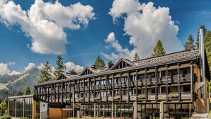 A modern hotel with multiple balconies, large windows, and a mountain backdrop. - HOTIDAY Apartment Collection - Campiglio Grostè (Pinzolo)