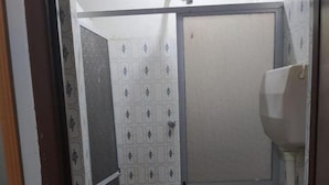 A small bathroom with a toilet, a sink, and a shower area. - hotel minas salvador (Salvador)