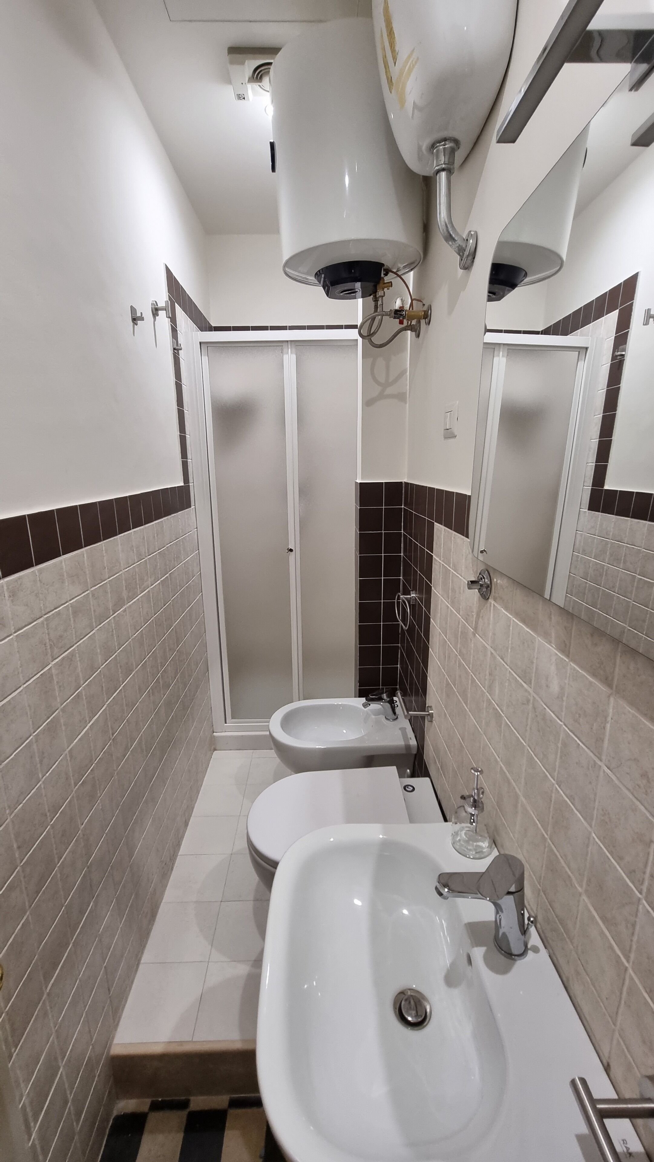 Een badkamer met twee wasbakken, een douche en een toilet.