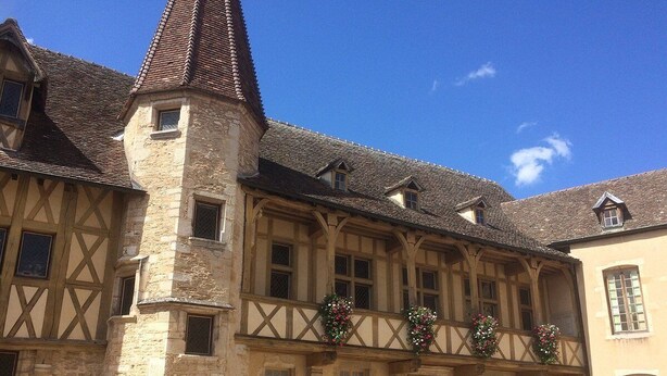 A historic building with a stone tower, timber framing, and a balcony with flower decorations. - Flat*** near Beaune center, quiet, swimming pool, sauna, golf (Levernois)