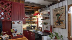 Una cocina con armarios de madera, un refrigerador y diversos utensilios de cocina.