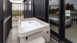 A spa tub on a balcony with a view of a residential area. - The Atlee Suites (Berlin)