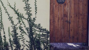 A wooden gate with a sign reading 'CASA SERENA' and a wall partially covered with green vines. - Casa Perezoso-Private pool- 800m from the beach. (Bahia Ballena)