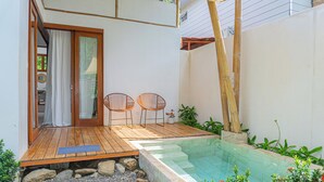 A wooden deck with two wicker chairs, a small pool, and a bamboo structure. - Casa Perezoso-Private pool- 800m from the beach. (Bahia Ballena)
