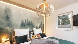 A neatly made bed with a green blanket, a fluffy pillow, and a bedside table with a tray of breakfast. - Ferienhaus Sonnenweg 32 - Sauna, Garten und Seeblick Inklusive (Diemelsee)