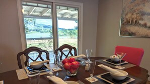 A dining table set with white bowls, a glass of water, and a bowl of red apples. - Osprey Bluff, Conveniently located with exceptional sunrises and lake views. (Clinton)