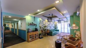 A hotel lobby with a reception desk, seating area, and a staircase leading to other floors. - Marina Beach Hotel (Tel Aviv)