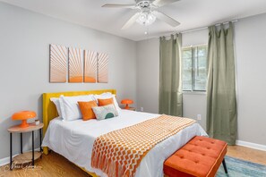 Bedroom featuring a queen-sized bed, a stylish end-of-bed bench, and a window  - Backyard - Games - Vibrant (Shreveport)