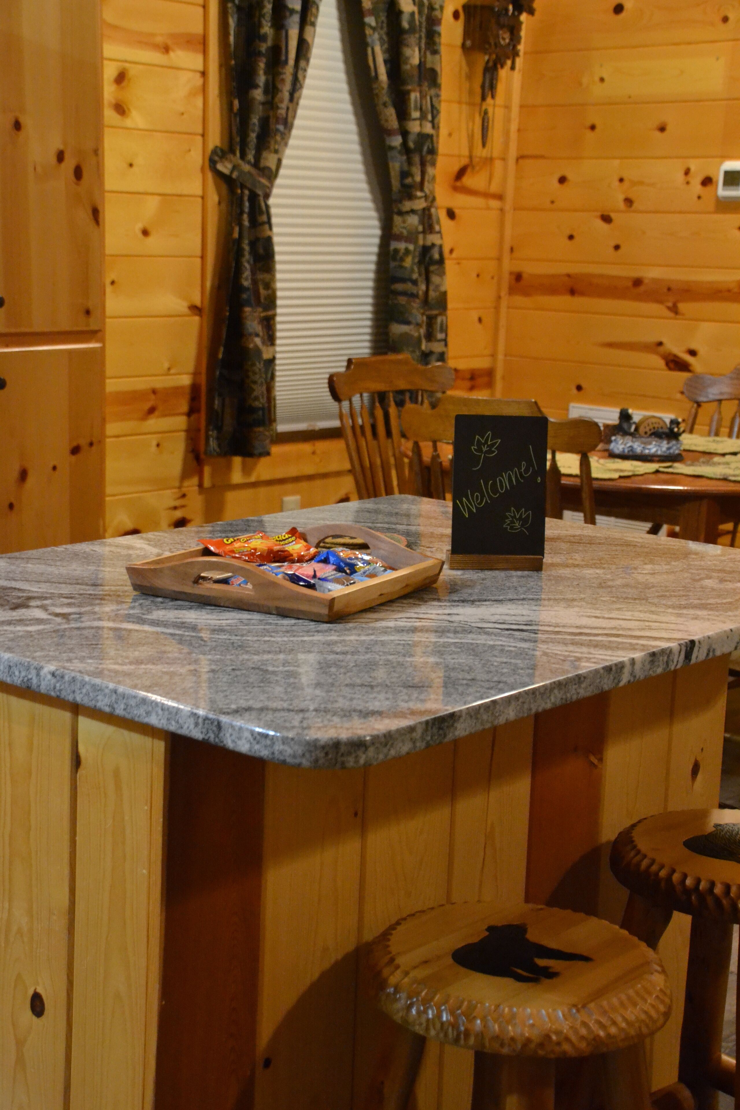 Un intérieur en bois avec un comptoir en marbre, un panneau d’accueil et un plateau de collations.