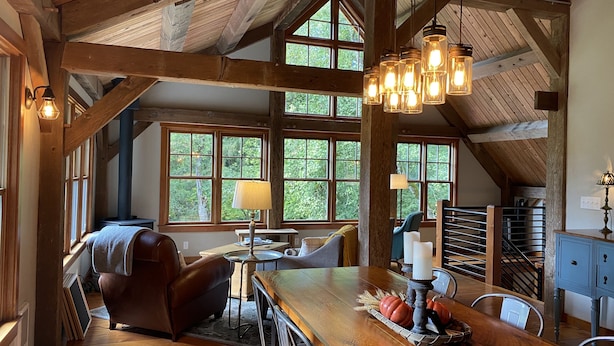 A rustic interior with a wooden dining table, leather chair, and a fireplace. - Escape the hustle and bustle and unwind at RIVERLOFT! Tranquility Awaits! (Scio)