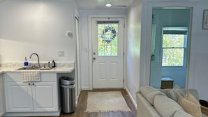 A modern kitchen with white cabinets, a stainless steel sink, and a window with a view. - Be our guest at The Nest!  (Pleasant Valley)