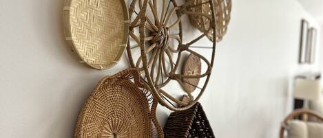 A wall decorated with various woven baskets and woven items.