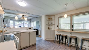 A modern kitchen with a central island, bar stools, and pendant lighting. - 5 Mi to Cataloochee Ski Area! Family Home w/ Views (Maggie Valley)