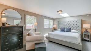 A bedroom with a bed, a dresser, a chair, and a large mirror. - 5 Mi to Cataloochee Ski Area! Family Home w/ Views (Maggie Valley)