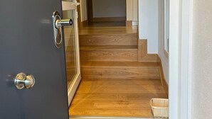 Un couloir avec un escalier en bois menant à l’étage supérieur.