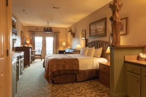 Relax in a traditional room with a large bed, wooden headboard, and a unique deer head on the wall.