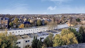 A residential area with a row of modern buildings, some with solar panels on the rooftops. - Bakersfield (London)