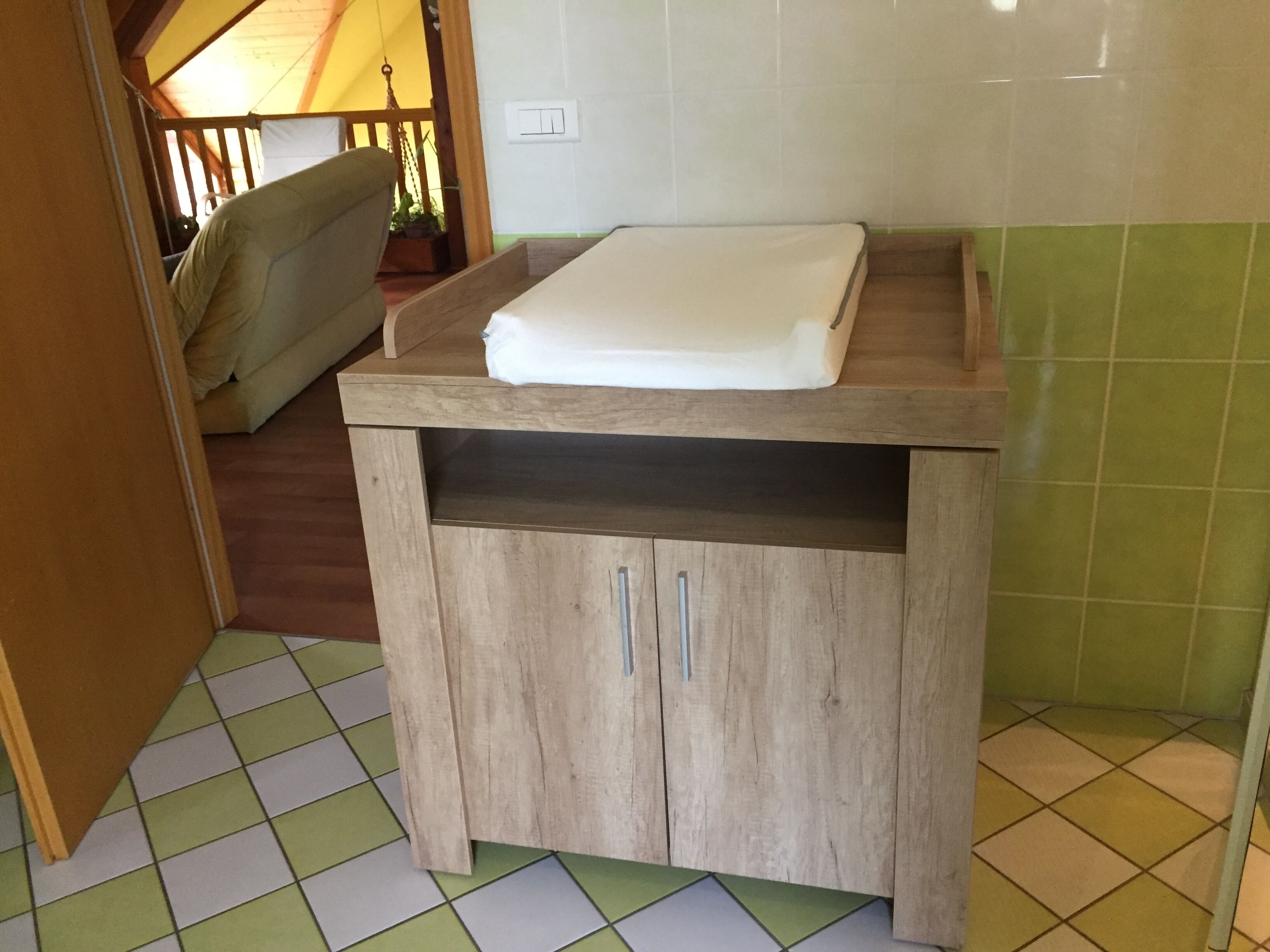 A small kitchen with a wooden countertop, a sink, and a tiled floor.