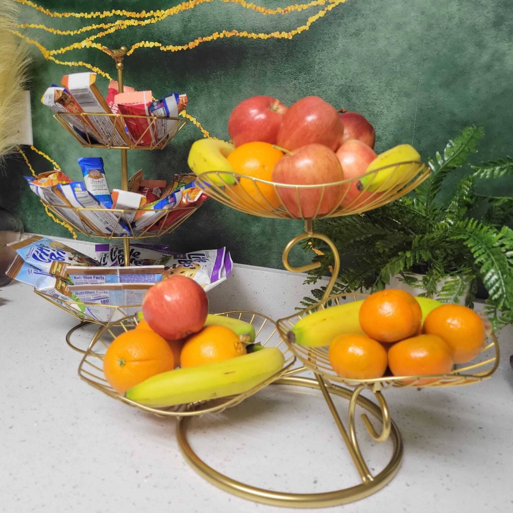 A fruit display with bananas, apples, and oranges on a table.