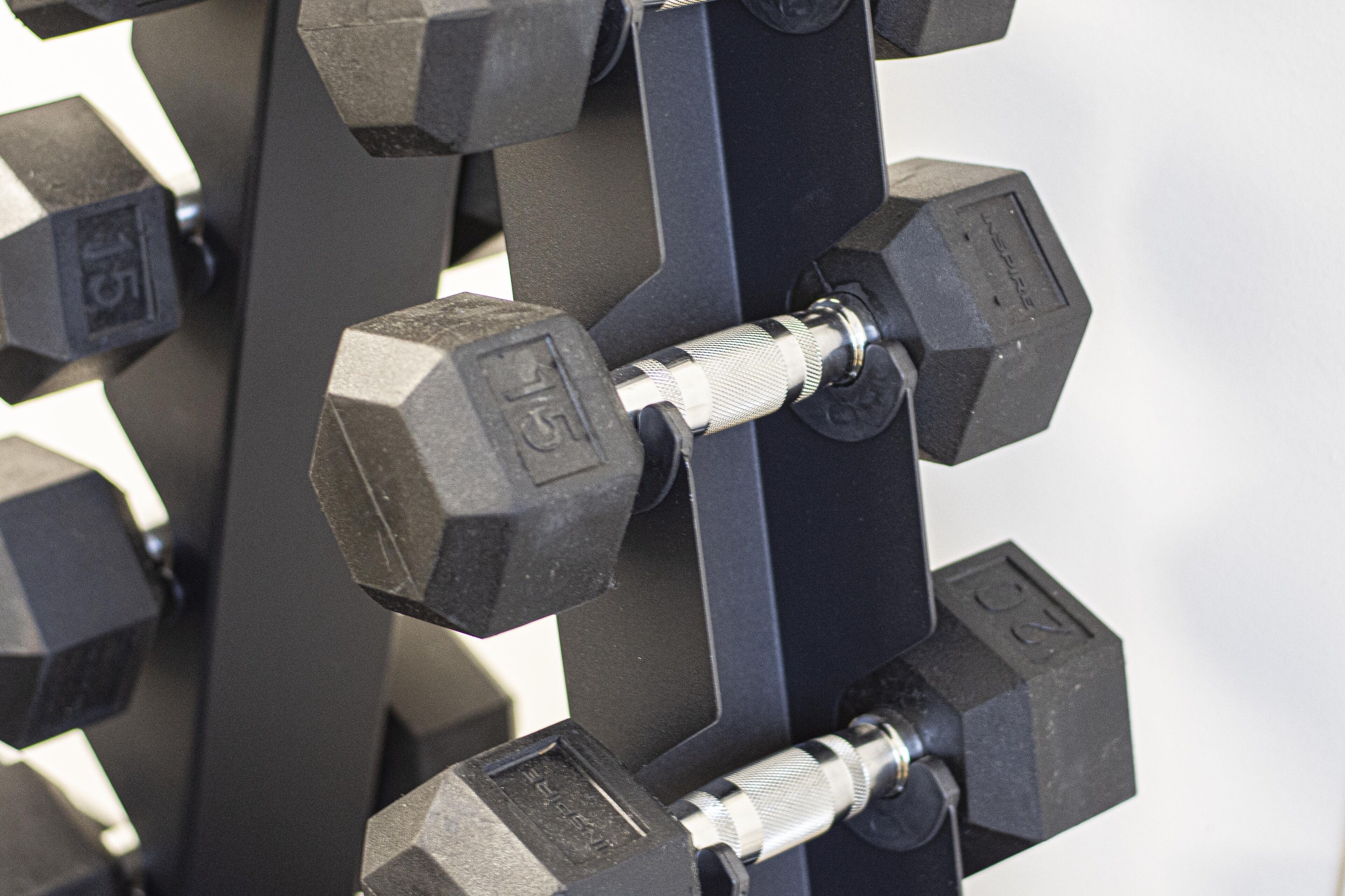 A close-up of a dumbbell rack with multiple weights.