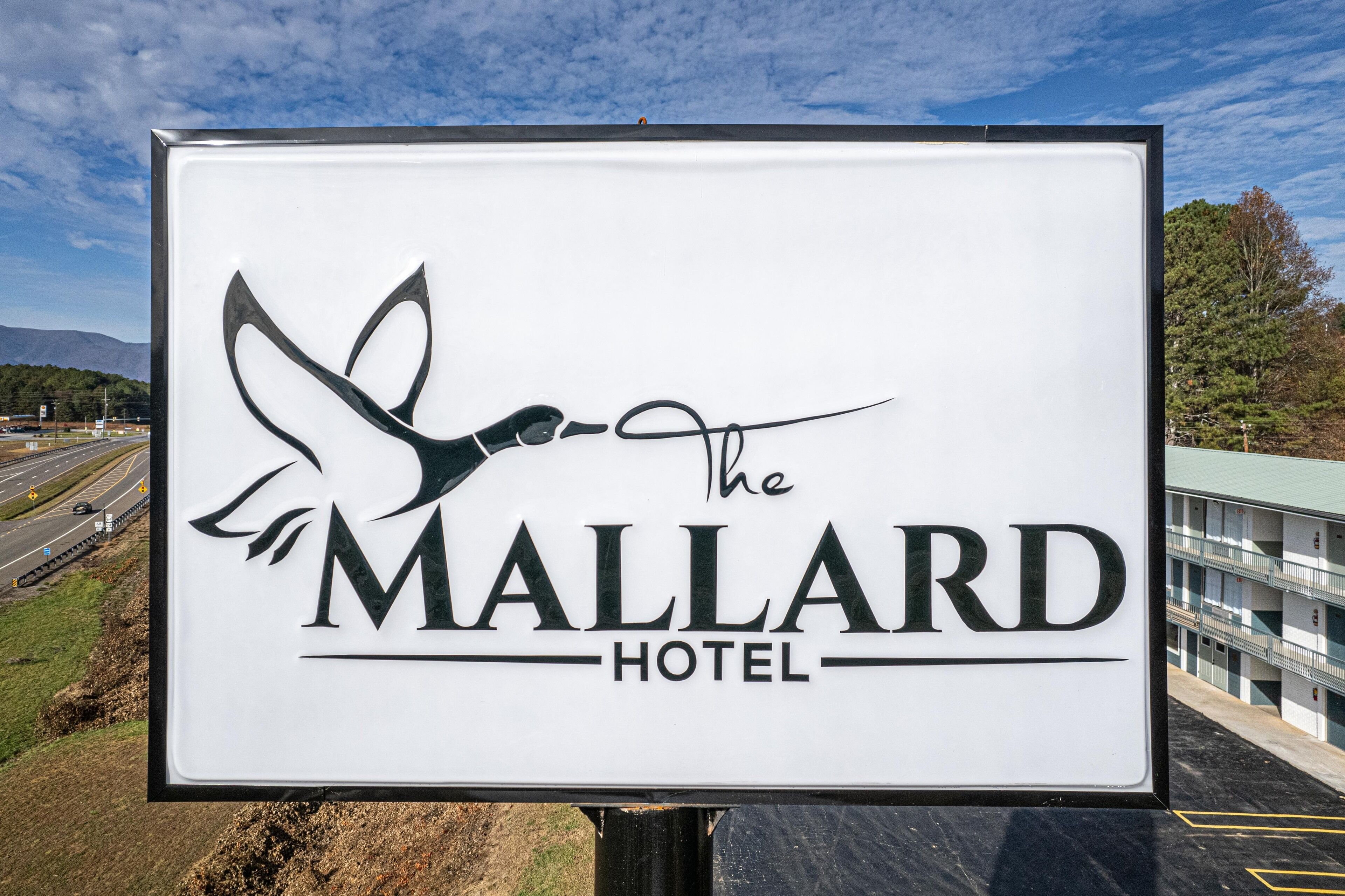A sign for The Mallard Hotel featuring a stylized bird logo and the hotel name.