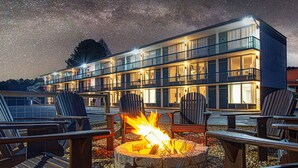 A hotel with multiple balconies, outdoor seating, and a fire pit. - The Mallard Hotel (Copperhill)