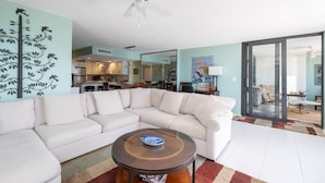 A modern living room with a sectional sofa, a glass coffee table, and a ceiling fan. - BEACH VACATION ON BEAUTIFUL SAND KEY CLEARWATER 3BR w/ Private Beach Access
(Clearwater)