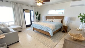 A spacious bedroom with a bed, a sofa, a desk, and a ceiling fan. - Beach Front Home in beautiful Playa Encanto gated community 3bed/3bath (Playa Encanto)